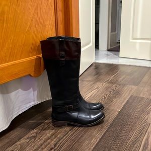 Genuine leather black riding boots with brown trim.